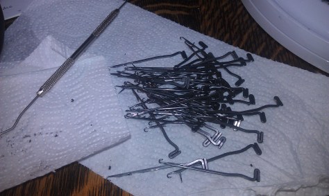 Needles being cleaned and latches oiled at the little hinges.