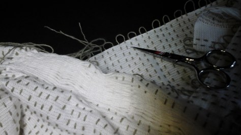 The start of gathering pattern threads on first long edge of scarf.